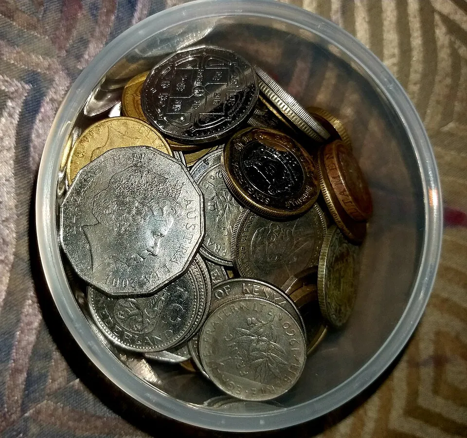 A jar full of coins from various countries